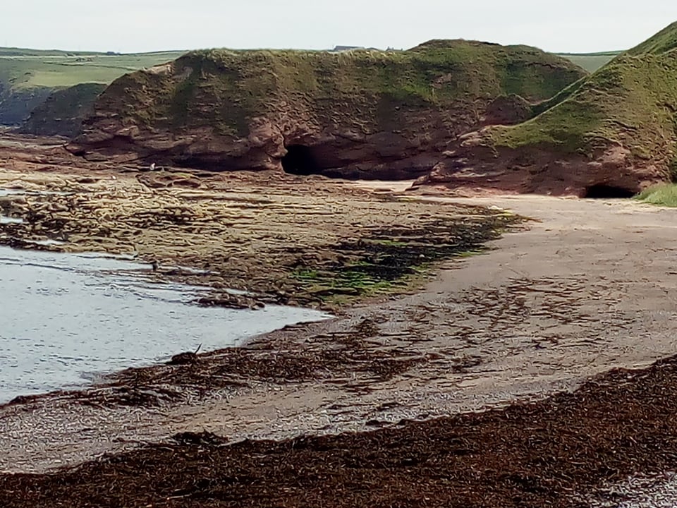 a rocky seashore and a cave at New Aberdour Beach