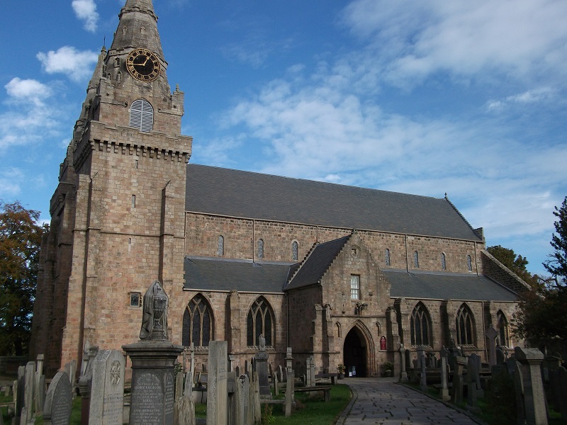 St Machar Cathedral in the sun, with gravestones in front 