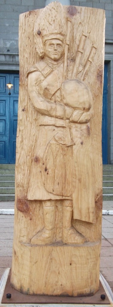 a wooden sculpture of a piper