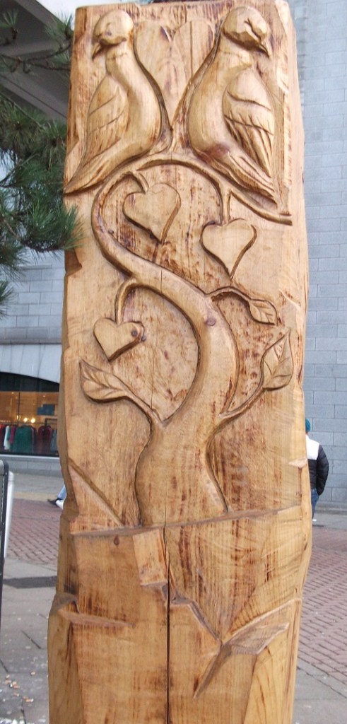 a wooden sculpture of two turtle doves
