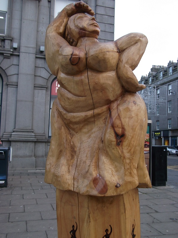a wooden sculpture of nine ladies dancing