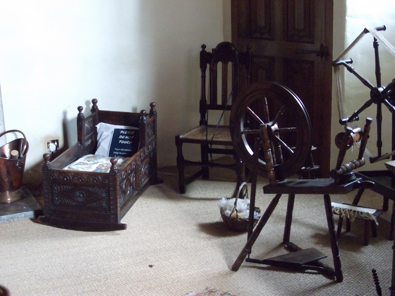 A wooden cradle and a spinning wheel