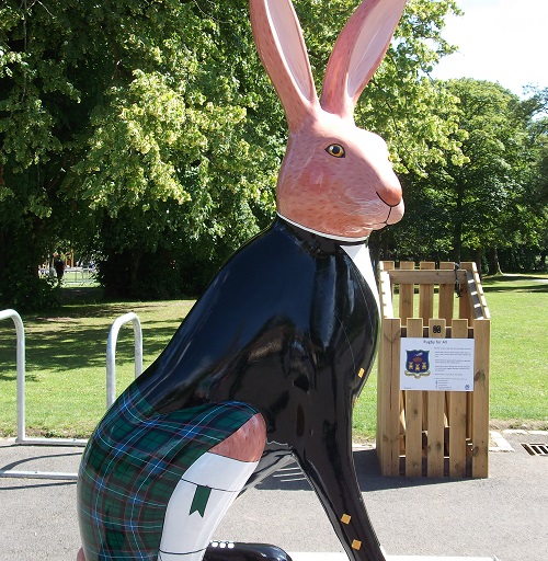 a hare sculpture with a painted black jacket and kilt