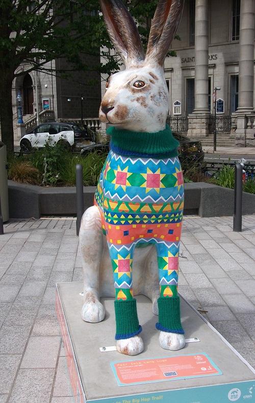 a hare sculpture with painted multicoloured woollen jacket