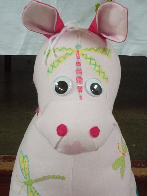 a pink toy animal with dragonflies 