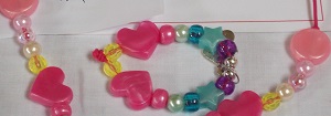 a necklace with beads and pink hearts