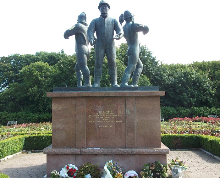 A memorial to the Piper Alpha disaster, showing three men in oil worker attire