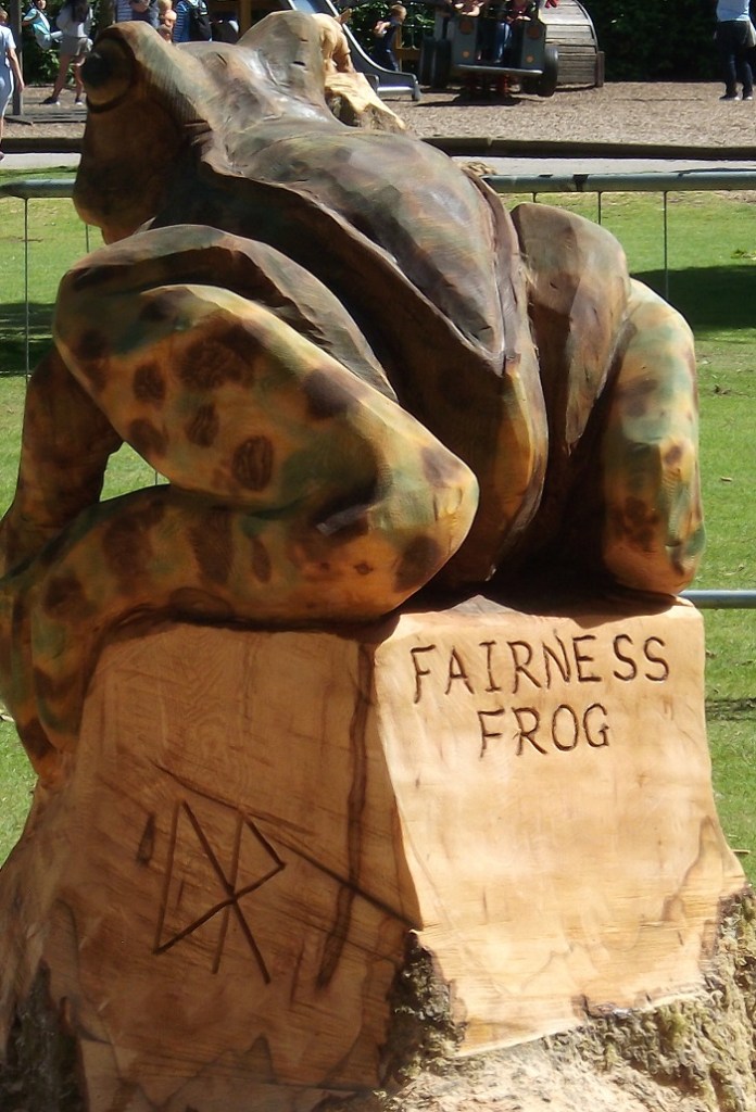 a wooden sculpture of a frog