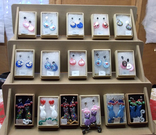 a variety of earrings in boxes, including coloured cats