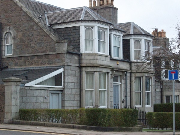 a house with unusual window frames featuring semi circular panes