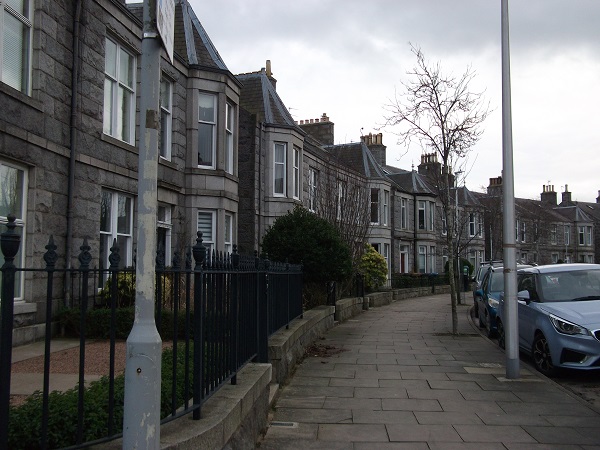 a row of houses with large windows and triangular turrets above