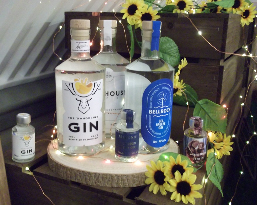 Bottles of clear liquid gin surrounded by sunflowers