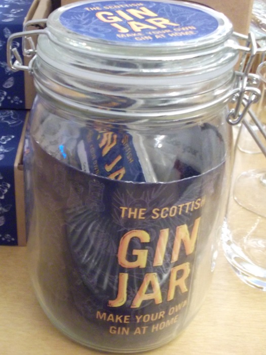 A clear jar with a blue label and text The Scottish Gin Jar