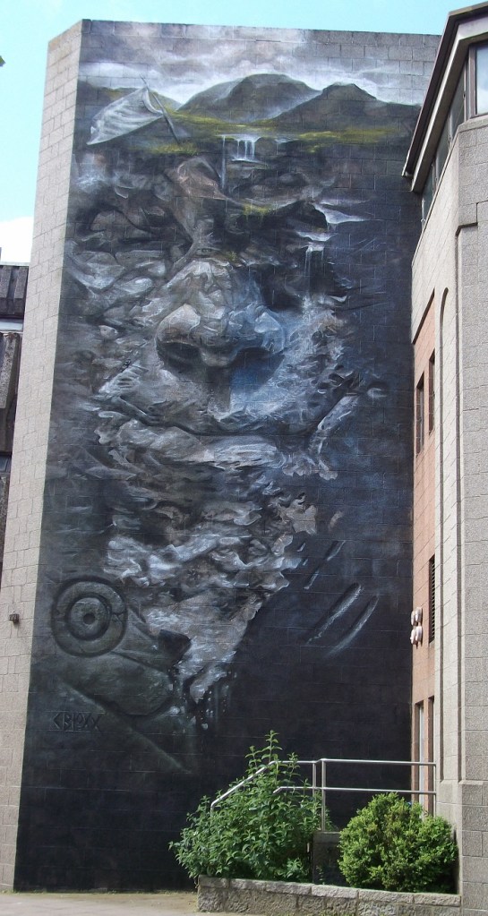 A grey face set against mountains