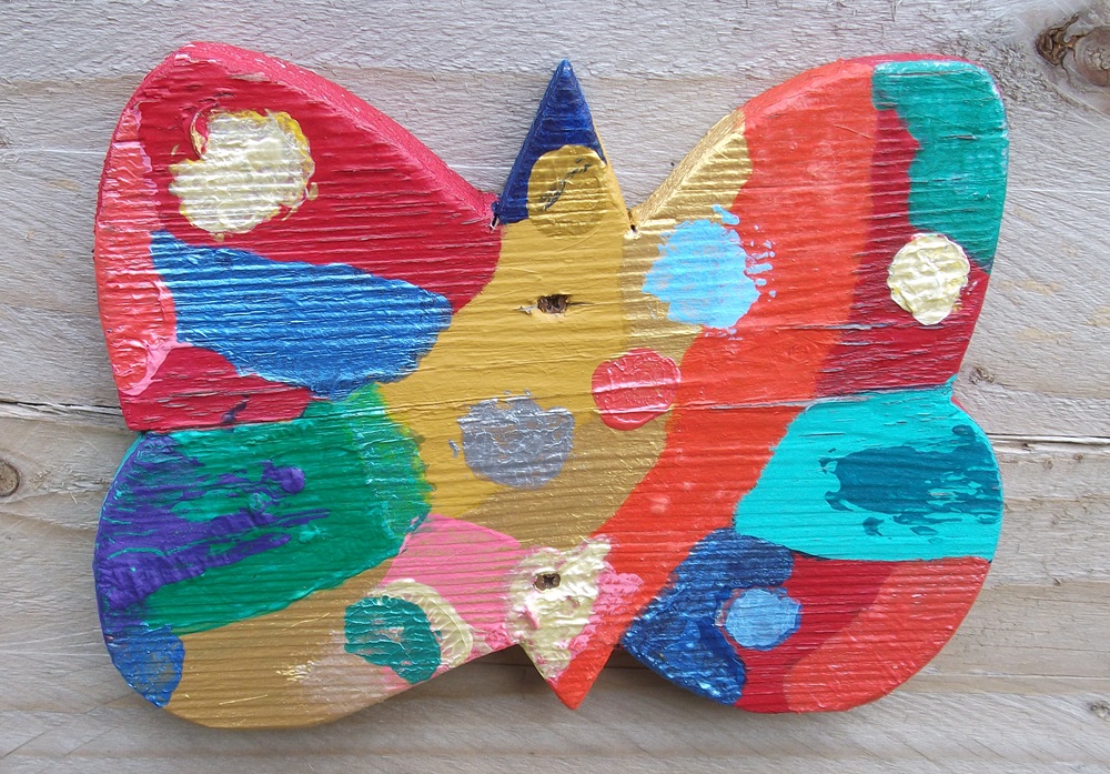 wooden butterfly painted red, green, blue and yellow