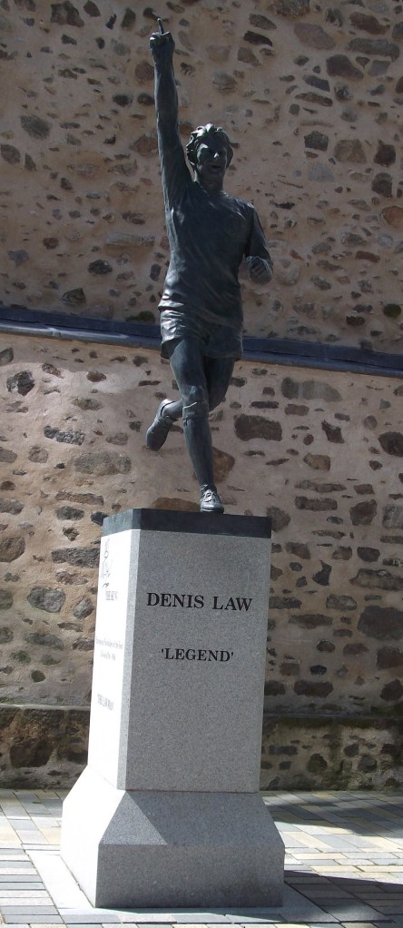 Statue of a running footballer with arm raised.