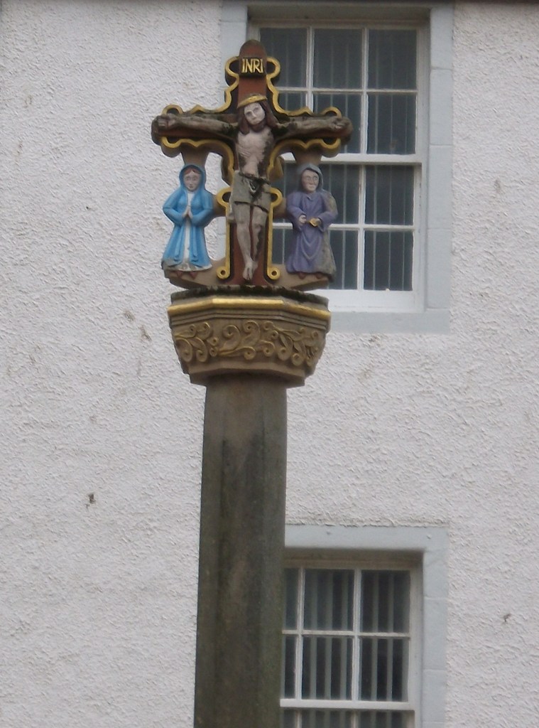 A market cross with Jesus on a cross and two cloaked figures on either side