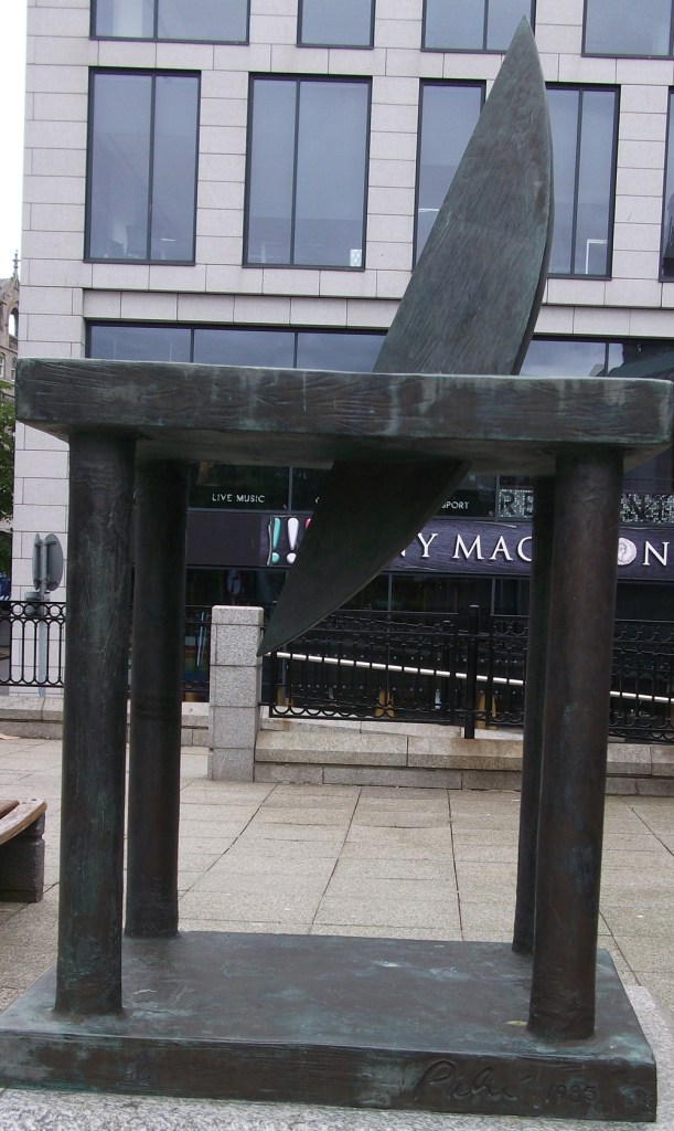 A sculpture of a new moon set in a granite plinth.