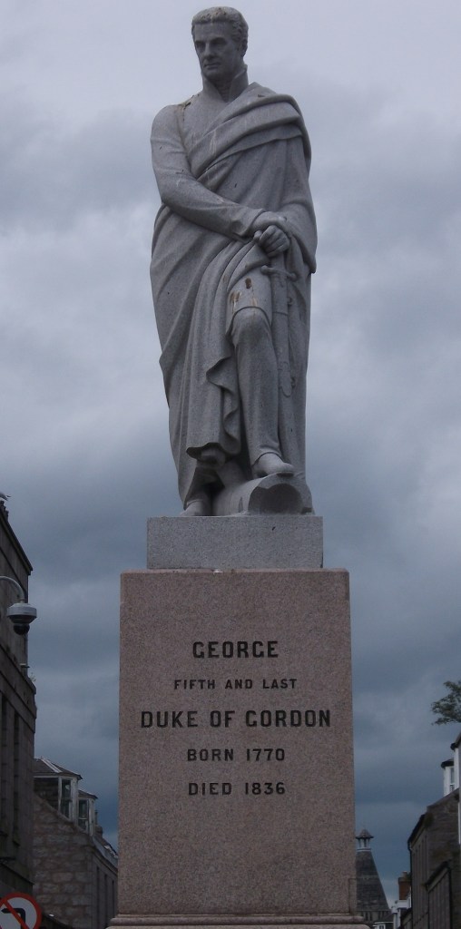 A statue of a man in robes holding a sword against his leg