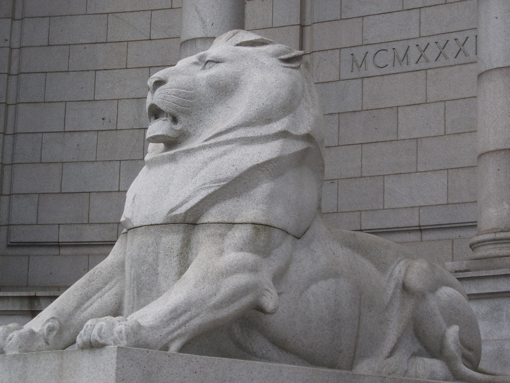 a statue of a lion with front legs stretched out