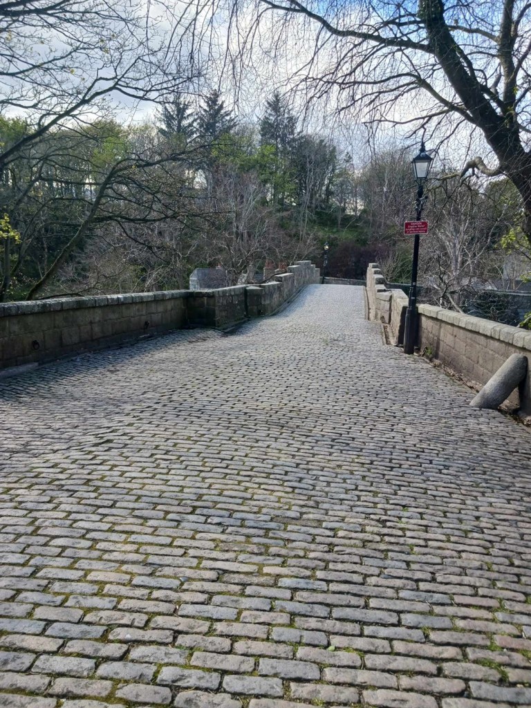 a cobbled stone path leads to a bridge
