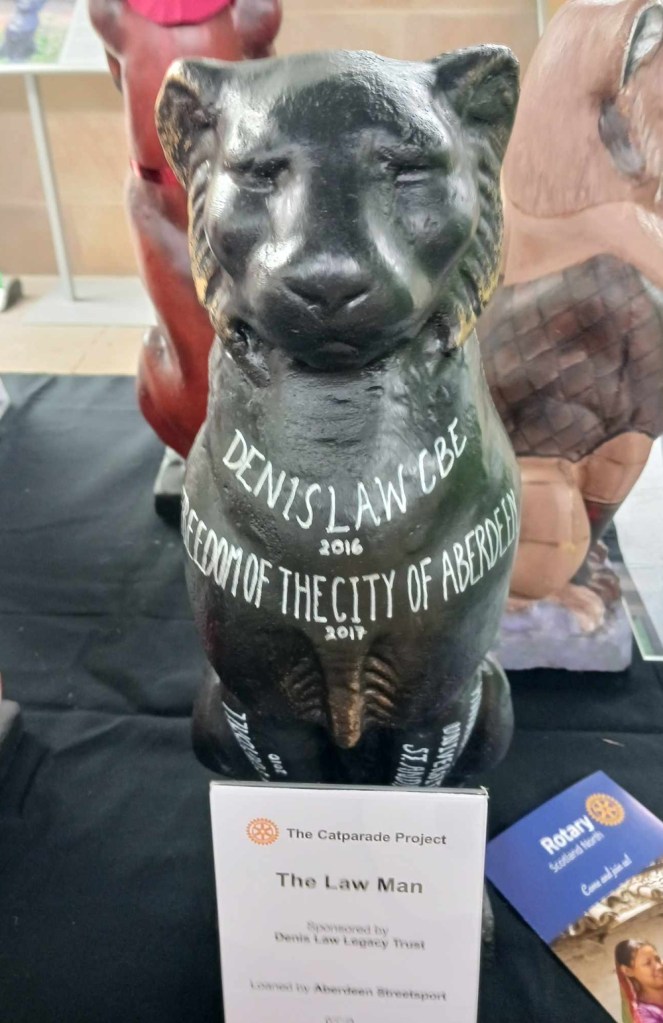 Black cat statue with text stating Denis Law CBE 2016; Freedom of the City of Aberdeen 2017