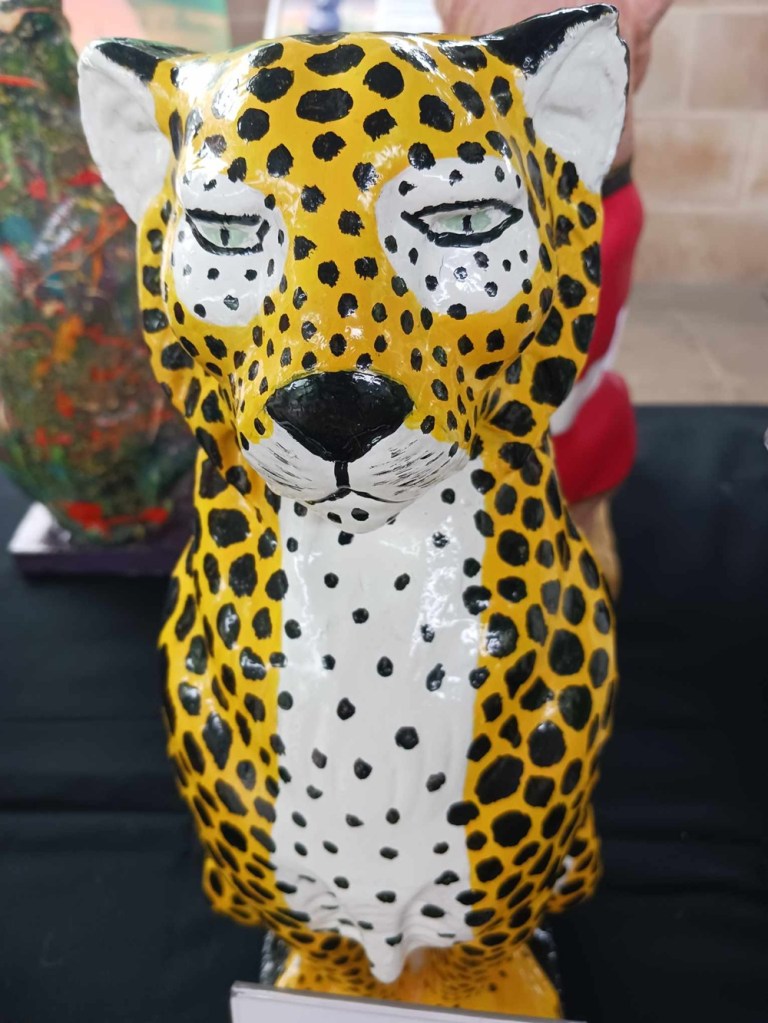A leopard cat statue in orange and white with black spots