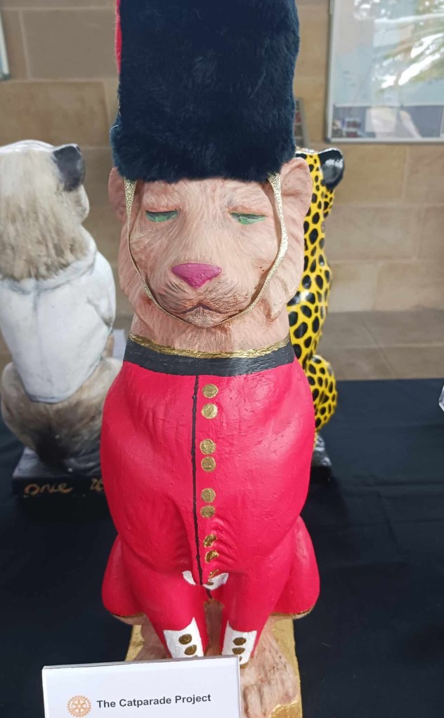 A cat statue with a black bearskin hat and red jacket