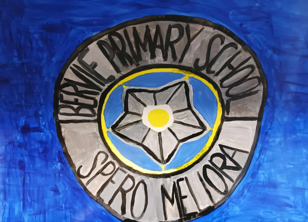 A blue background is overlaid by a grey circle with a yellow and grey flower and lettering Bervie Primary School Spero Mellora