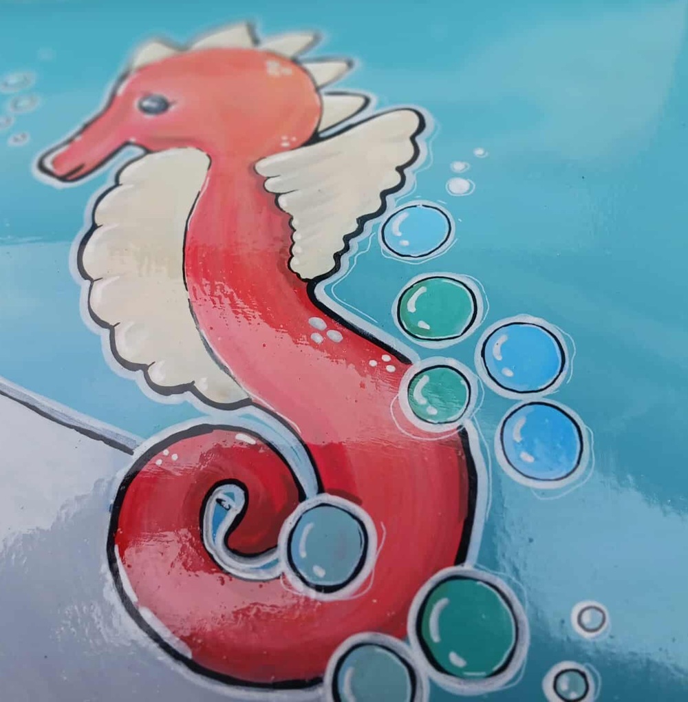 A painting of an orange seahorse