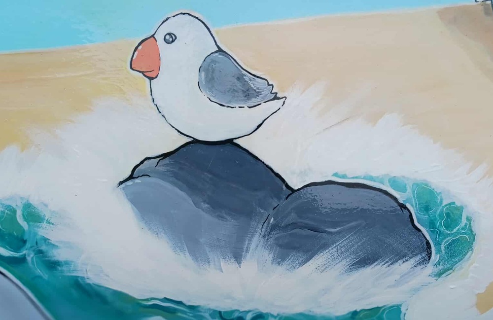 A painting of a seagull on a rock