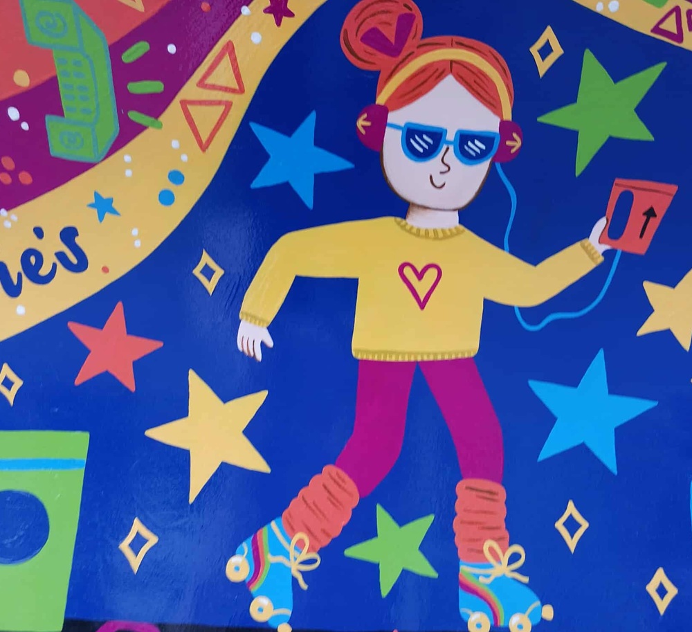 a figure with headphones, yellow jumper with heart on it, dark pink leggings, orange legwarmers and blue rollerskates