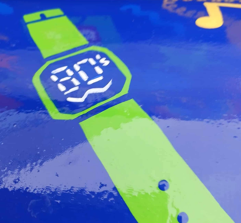 a green watch with 80s written on its face