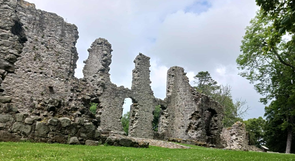 Stone walls of a ruined castle, with grass around them