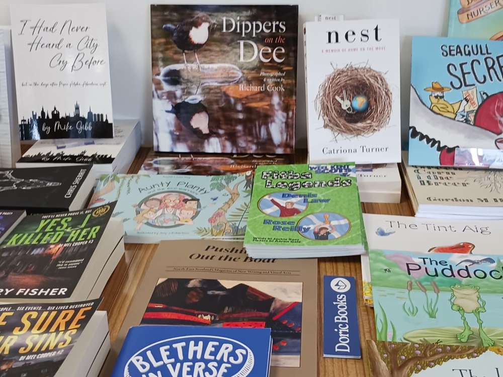 Colourful books on a table, including Dippers on the Dee, Nest and I Had Never Heard a City Cry Before