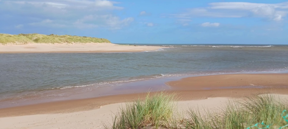 sand stretches to an estuary which joins the sea beyond