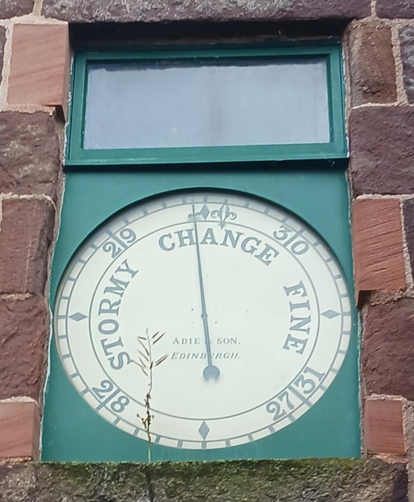 A barometer clockface with words Stormy Change and Fine