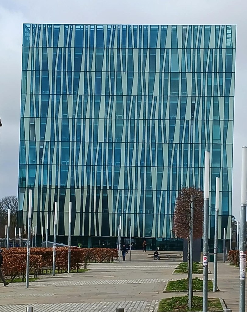 A cube shaped building with a design of wavy lines across its front
