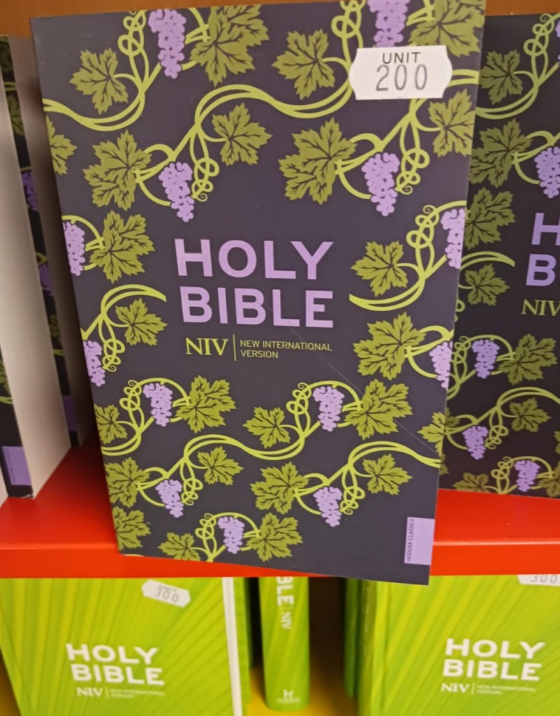 A Holy Bible with a purple and green leaf cover