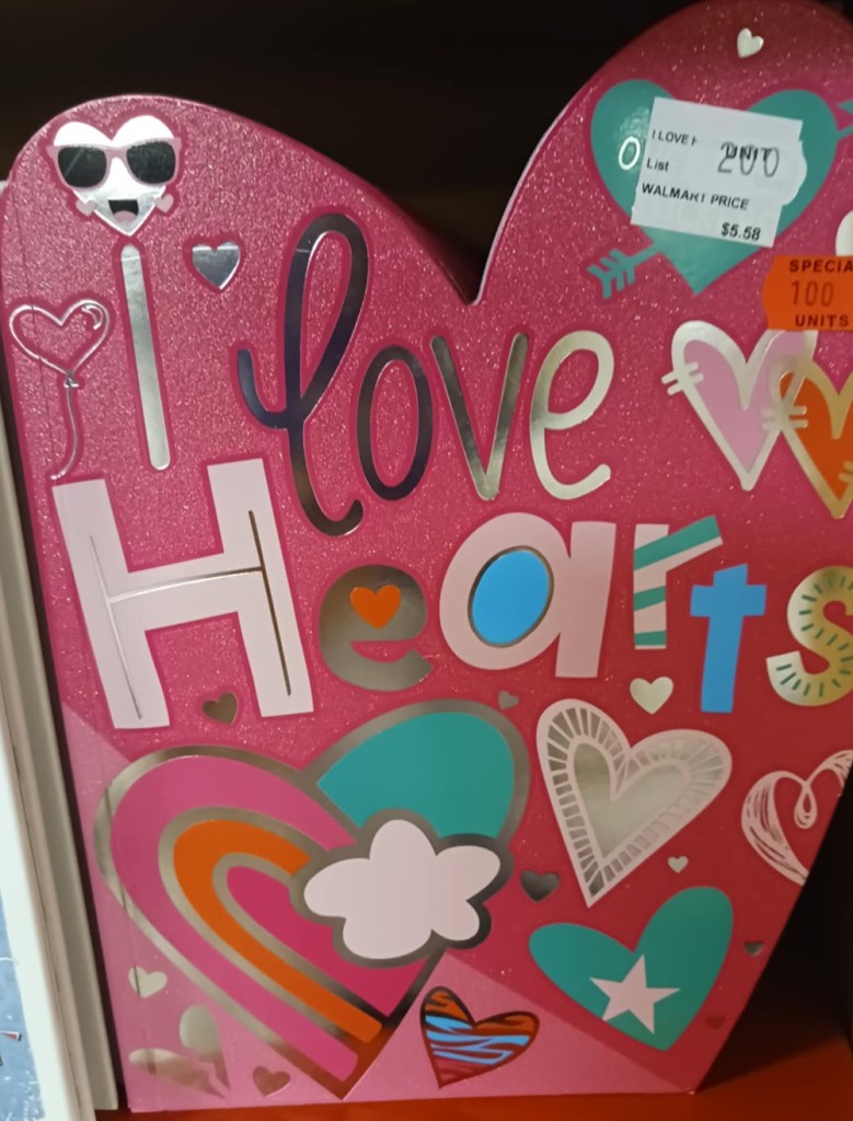 A heart shaped pink book cover with wording I love Hearts