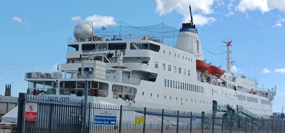 A large white sailing vessel against a blue sky